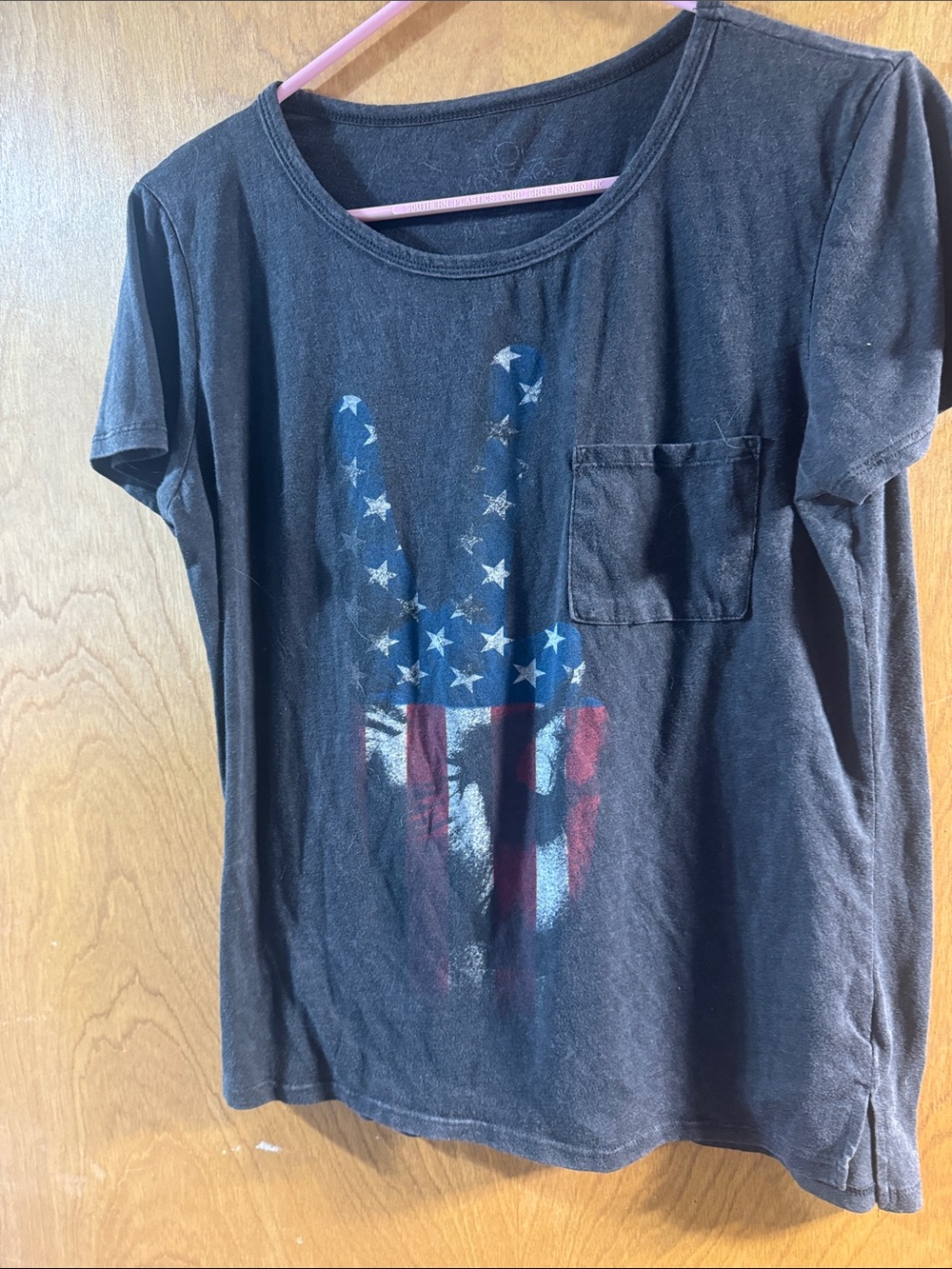 Ladies Black Pocket Tee with Flag Peace Hand Graphic